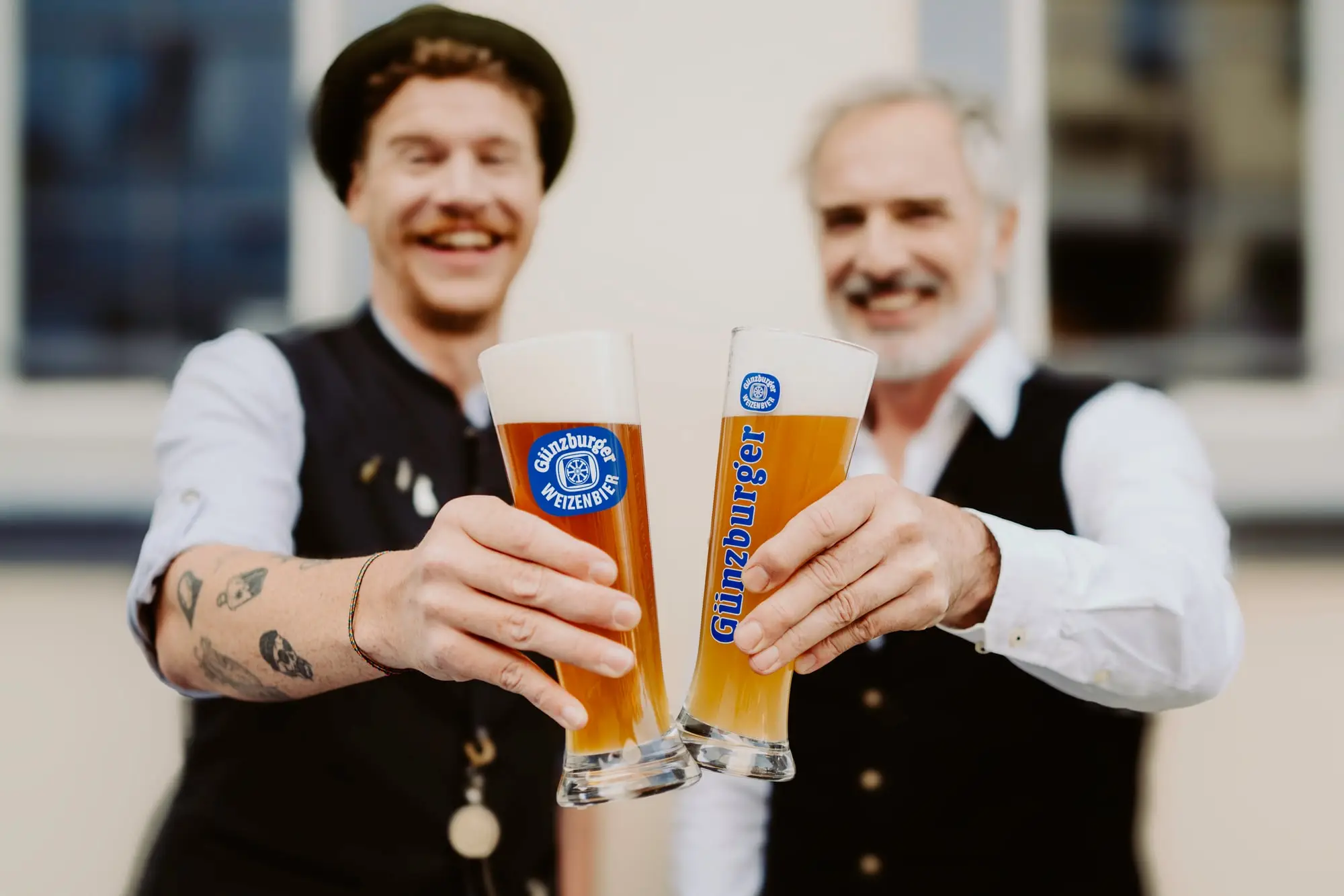 Zwei Männer stoßen mit Günzburger Weizen an