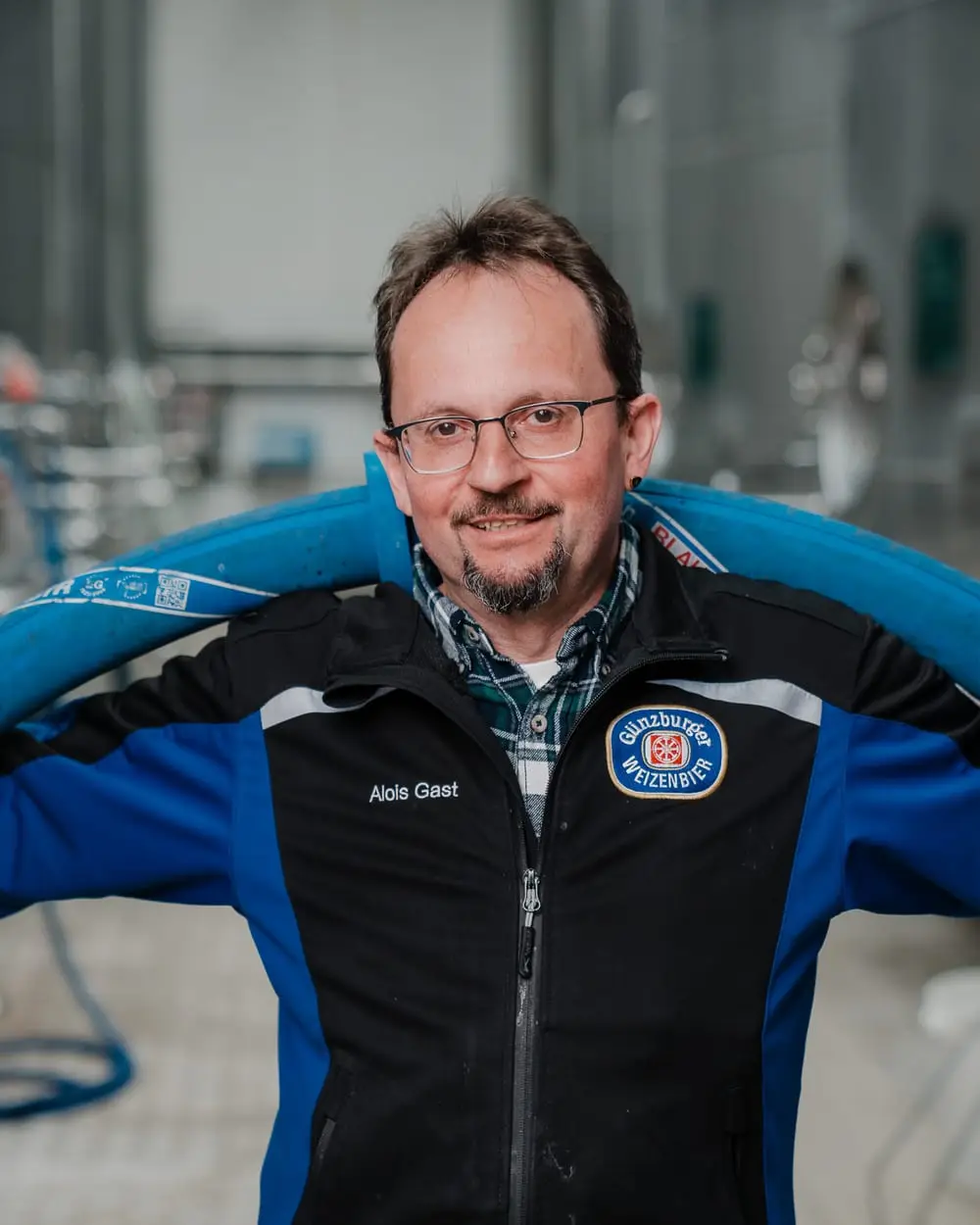 Mitarbeiter mit Schlauch über der Schulter