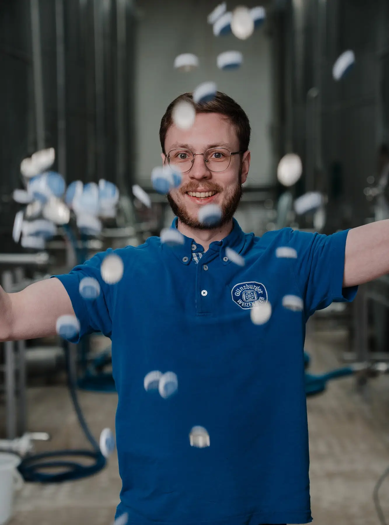 Mitarbeiter der Radbrauerei wirft Kronkorken in die Luft
